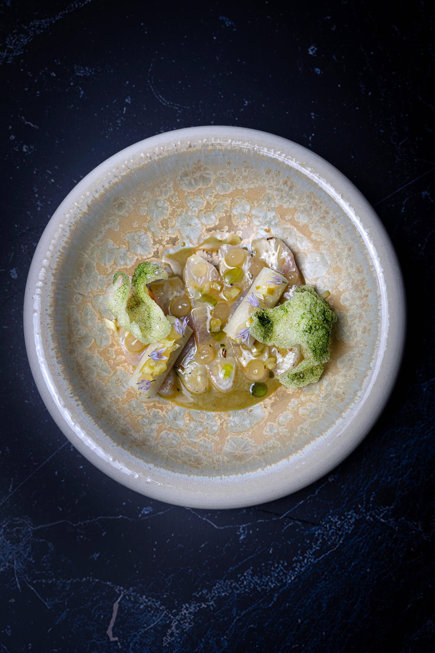 In koffie ingelegde hamachi met yuzu-limoenblad vinaigrette, algenkroepoek en citrus